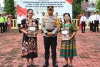 Kapolres Nias AKBP Revi Nurvelani memberikan penghargaan kepada dua warga yang membantu mengungkap kasus pembunuhan. Foto: Humas Polres Nias