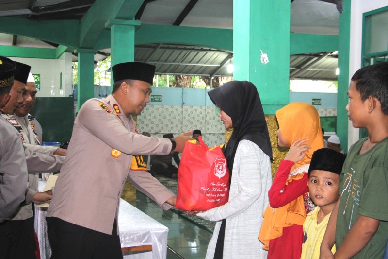 Kapolres Nias AKBP Revi Nurvelani menyerahkan tali asih kepada anak yatim piatu dan fakir miskin dalam kegiatan buka puasa bersama Keluarga Besar Polres Nias. Foto: Humas Polres Nias