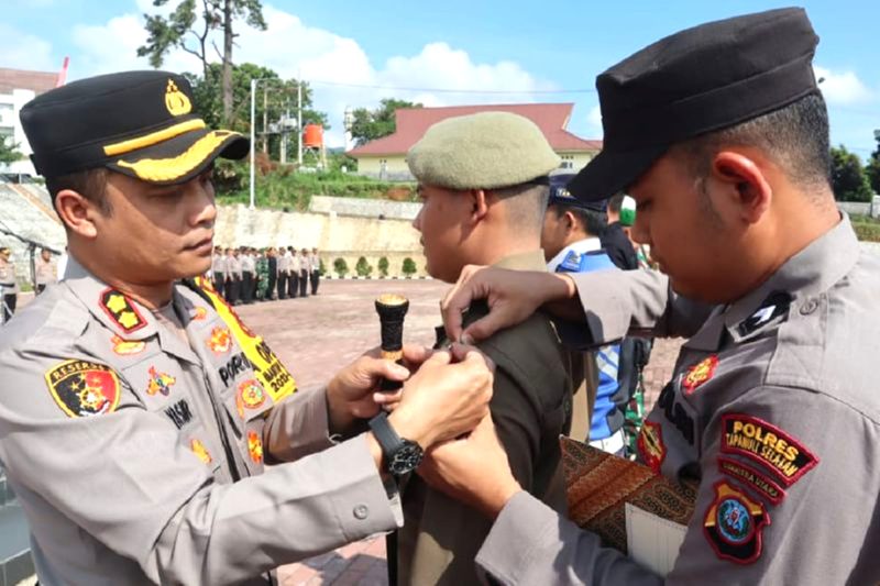 Kepala Polres Tapsel AKBP Yasir Ahmadi menyematkan pita kepada personel dalam Operasi Ketupat Toba 2024 untuk pengamanan Lebaran 2024 di Padangsidimpuan, Kabupten Tapsel, Jumat (5/4/2024). Foto: Polres Tapanuli Selatan