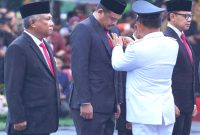 Menteri Dalam Negeri Tito Karnavian memasangkan lencana Satyalancana Karya Bhakti Praja Nugraha kepada Wali Kota Medan Bobby Nasution di Balai Kota Surabaya, Jawa Timur, Kamis (25/4). Foto: Antara
