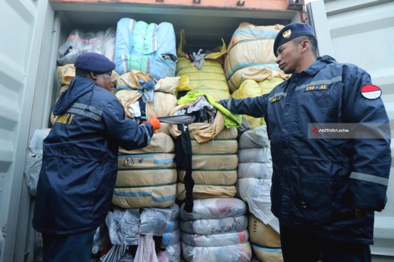 Anggota TNI Angkatan Laut menunjukkan barang bukti pakaian bekas saat ungkap kasus penggagalan penyelundupan pakaian bekas impor ilegal di Surabaya, Jawa Timur, Rabu (8/8). Foto: Arsip Antara