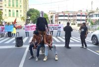 Aksi teatrikal dari Massa Front Marhaenis Indonesia saat melakukan unjukrasa di Kantor Walikota Medan, Senin (26/8). Foto: Satria Hadhi Ningtyas/topikseru.com