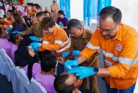 Director & CFO PT Agincourt Resources (PTAR) Noviandri (kanan) meneteskan obat mata ke pasien yang telah menjalani operasi katarak saat penutupan operasi katarak gratis 2024 Tambang Emas Martabe, Senin (9/9/2024). Ia didampingi Plt. Kepala Dinas Kesehatan Sumatra Utara Basarin Yunus Tanjung (kedua dari kanan) dan Senior Manager Corporate Communications PTAR Katarina Siburian Hardono (ketiga dari kanan). Foto: Dok PTAR