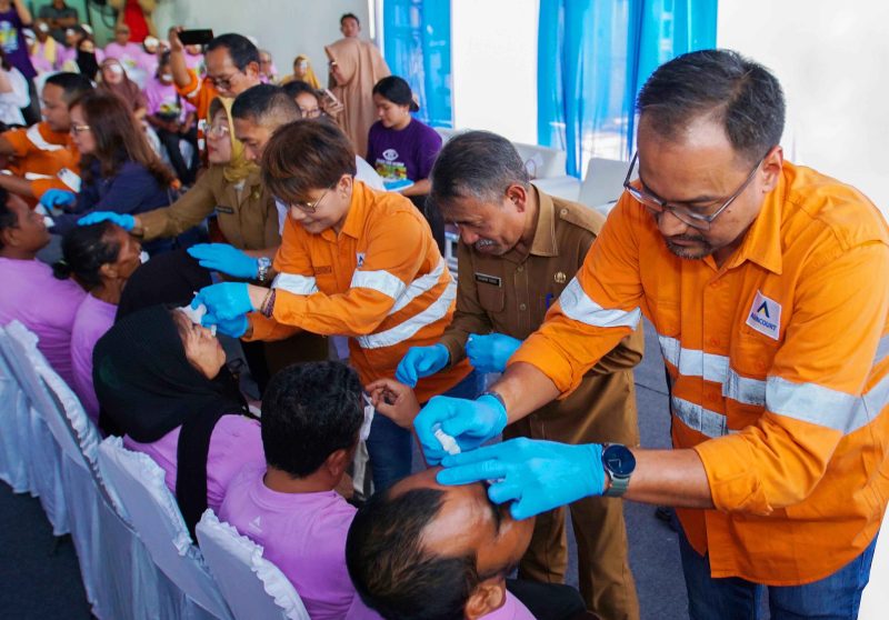 Director & CFO PT Agincourt Resources (PTAR) Noviandri (kanan) meneteskan obat mata ke pasien yang telah menjalani operasi katarak saat penutupan operasi katarak gratis 2024 Tambang Emas Martabe, Senin (9/9/2024). Ia didampingi Plt. Kepala Dinas Kesehatan Sumatra Utara Basarin Yunus Tanjung (kedua dari kanan) dan Senior Manager Corporate Communications PTAR Katarina Siburian Hardono (ketiga dari kanan). Foto: Dok PTAR