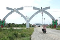 Pengendara sepeda motor melintasi Gapura Sport Center yang menjadi salah satu pintu menuju Stadion Utama Sport Center di Desa Sena, Kabupaten Deli Serdang, Sumatera Utara. Foto: Dok. Tim KJI Sumut