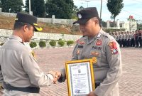 Kapolres Tapanuli Selatan AKBP Yasir Ahmadi menyerahkan piagam penghargaan kepada Brigadir Erlangga Gautama Nasution yang sukses dalam pengelolaan media sosial (medsos). Foto: Humas Polres Tapsel