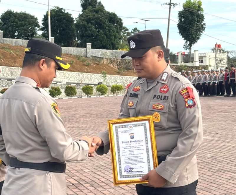 Kapolres Tapanuli Selatan AKBP Yasir Ahmadi menyerahkan piagam penghargaan kepada Brigadir Erlangga Gautama Nasution yang sukses dalam pengelolaan media sosial (medsos). Foto: Humas Polres Tapsel