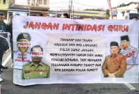 Guru honorer korban kecurangan seleksi PPPK Kabupaten Langkat tahun 2023 bentangkan spanduk saat menggelar demonstrasi di depan gerbang Polda Sumut. Foto: Dok. LBH Medan
