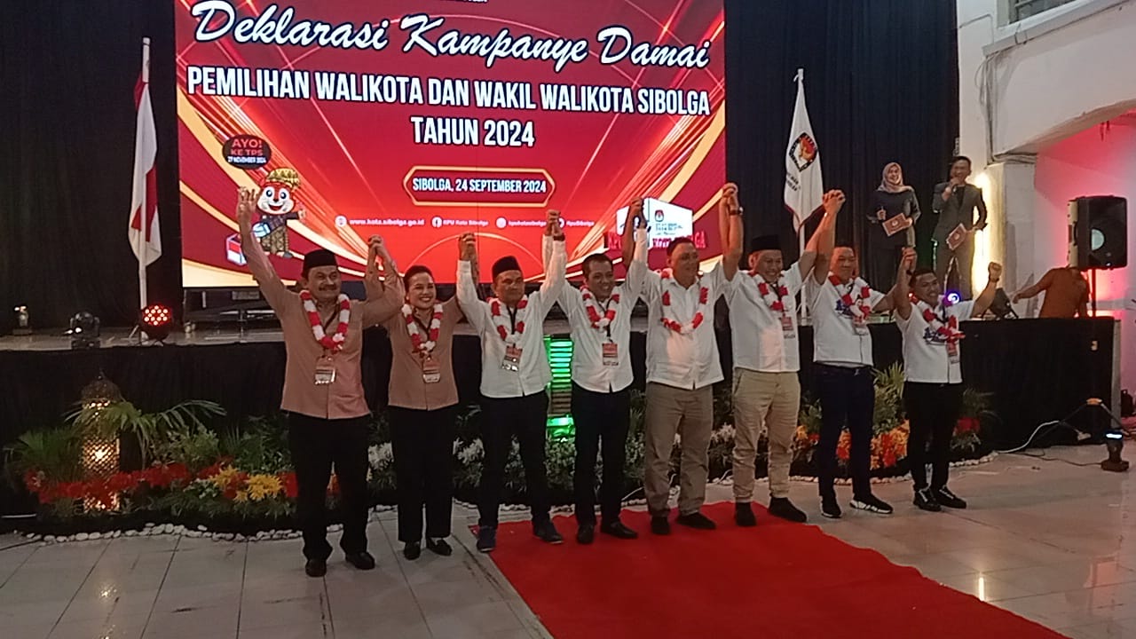 Empat pasang calon Walikota dan Wakil Walikota Sibolga 2024, saling bergandeng tangan menunjukan komitmen dalam menjaga Kondusifitas pada Deklarasi Kampanye Pilkada Damai, di Gedung Nasional Kota Sibolga, Selasa (24/09/2024) malam. Dok. Topikseru.com/ Jasman Julius.