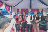 Tokoh masyarakat Nias Marinus Gea dan Ketua DPC HIMNI Tapteng Famoni Gulo diapit pasangan MaMa setelah tandatangani kontrak politik dalam Pagelaran Seni dan Budaya Nias, Kamis (14/11). Foto: Topikseru.com/ Jasman Julius.