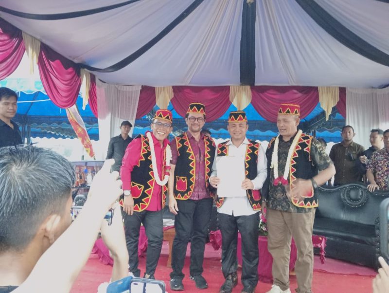 Tokoh masyarakat Nias Marinus Gea dan Ketua DPC HIMNI Tapteng Famoni Gulo diapit pasangan MaMa setelah tandatangani kontrak politik dalam Pagelaran Seni dan Budaya Nias, Kamis (14/11). Foto: Topikseru.com/ Jasman Julius.