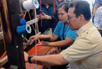 Menteri Perdagangan (Mendag) Budi Santoso belajar menggunakan alat tenun kain tradisional Ulos dan Songket di pusat kerajinan UMKM Galeri Ulos Sianipar di Kota Medan, Selasa (17/12). Foto: topikseru.com/Amar Fuad Marpaung 