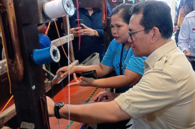 Menteri Perdagangan (Mendag) Budi Santoso belajar menggunakan alat tenun kain tradisional Ulos dan Songket di pusat kerajinan UMKM Galeri Ulos Sianipar di Kota Medan, Selasa (17/12). Foto: topikseru.com/Amar Fuad Marpaung 