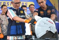 Seorang pejabat bea cukai Indonesia menunjukkan iPhone 16 Pro Max yang diselundupkan sebelum menghancurkannya, setelah disita bersama puluhan ponsel dan tablet Apple, di kantor bea cukai Bandara Internasional Soekarno–Hatta di Tangerang, Banten, 29 November 2024. Foto: AFP