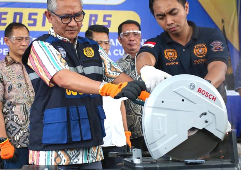Seorang pejabat bea cukai Indonesia menunjukkan iPhone 16 Pro Max yang diselundupkan sebelum menghancurkannya, setelah disita bersama puluhan ponsel dan tablet Apple, di kantor bea cukai Bandara Internasional Soekarno–Hatta di Tangerang, Banten, 29 November 2024. Foto: AFP
