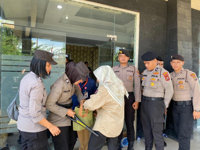 Personil kepolisian memeriksa tamu dan undangan yang hadir dalam Rapat Pleno Terbuka Rekapitulasi KPU Tapteng memakai Metal Detektor, Minggu (1/12). Foto: Humas Polres Tapteng