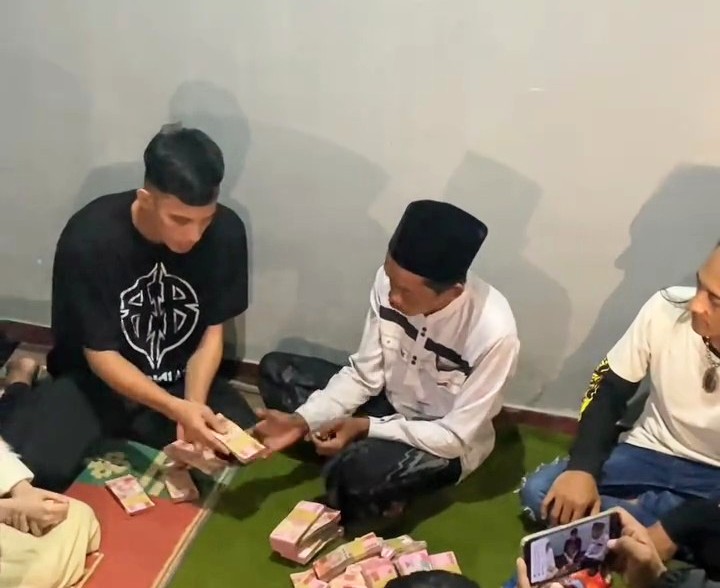 TikToker Rian Arifin saat menyerahkan uang donasi Rp 300 juta kepada pedagang es teh Sunhaji di kediamannya. Foto: tangkapan layar video
