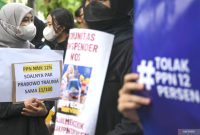 Sejumlah pengunjuk rasa membawa poster saat aksi penolakan PPN 12 persen di depan Istana Merdeka, Jakarta, Kamis (19/12/2024). Foto: Antara
