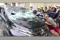 Mobil Mitsubishi Xpander yang dikendarai diduga pelaku tabrak lari di Medan menjadi bulan-bulanan warga yang emosi. Foto: Tangkapan layar video