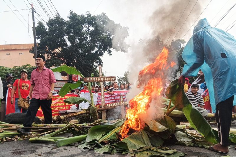 Ratusan warga memblokade Jalan Pantai Timur dalam aksi menolak rencana eksekusi lahan oleh PN Medan, Kamis (23/1). Foto: topikseru.com/Muchlis