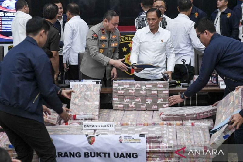 Dirtipideksus Bareskrim Polri Brigjen Pol Helfi Assegaf (kanan) bersama Karo Penmas Div Humas Polri Brigjen Pol Trunoyudo Wisnu Andiko (kiri) menunjukan barang bukti uang saat konferensi pers terkait penetapan tersangka Tindak Pidana Pencucian Uang (TPPU) hasil judi 'online' di Gedung Bareskrim Mebes Polri, Jakarta, Kamis (16/1/2025). ANTARA FOTO/Hafidz Mubarak 