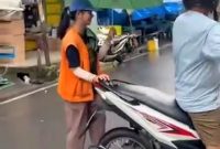 Wenni Jesika Silitonga, mahasiswi UI membantu perekonomian keluarga dengan menjadi juru parkir di Jalan Letjen S Parman Kota Tebing Tinggi, Sumut. Foto: tangkapan layar