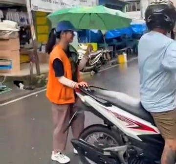 Wenni Jesika Silitonga, mahasiswi UI membantu perekonomian keluarga dengan menjadi juru parkir di Jalan Letjen S Parman Kota Tebing Tinggi, Sumut. Foto: tangkapan layar