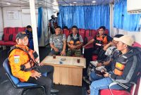 Komandan Pos SAR Sibolga, Rufinus Bangun (kiri), bersama ketiga korban saat dievakuasi dalam Kapal KN SAR Nakula, Selasa (7/1). Foto: dok. Pos SAR Sibolga