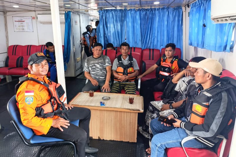 Komandan Pos SAR Sibolga, Rufinus Bangun (kiri), bersama ketiga korban saat dievakuasi dalam Kapal KN SAR Nakula, Selasa (7/1). Foto: dok. Pos SAR Sibolga