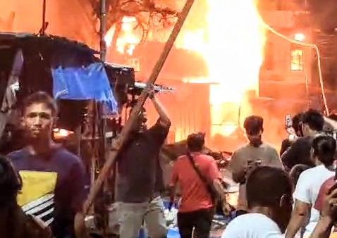 Pedagang Pasar Sibolga Nauli menyelamatkan barang-barang saat terjadi kebakaran pada Rabu (29/1) malam. Foto: tangkapan layar