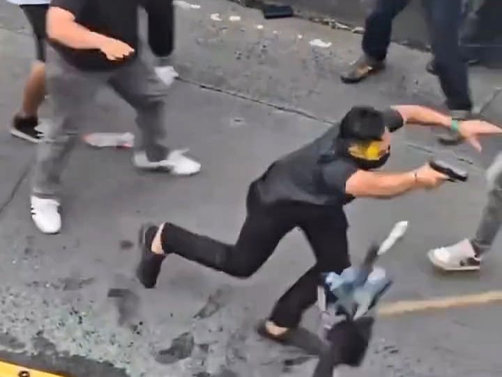 Seorang pria yang diduga anggota intelijen ketahuan saat menyusup ke barisan massa aksi dan acungkan pistol. Foto: Tangkapan layar video