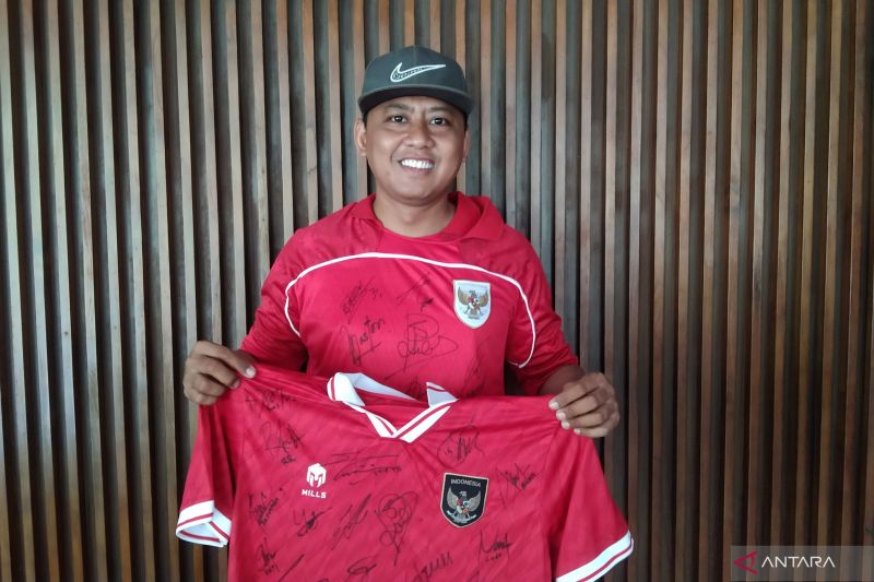 Seorang fans Tim Nasional (Timnas) Indonesia Heri Istiawan menunjukkan jersi dengan penuh tanda tangan para pemain Timnas Indonesia di Sanur, Denpasar, Bali, Minggu (1/6/2025).Foto: Antara/Dewa Ketut Sudiarta Wiguna
