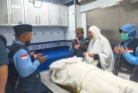 Istri almarhum mendampingi jenazah suaminya yang wafat, didampingi petugas haji kloter 9, Jumat (20/6).