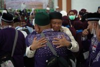 Sanak keluarga jemaah haji menyambut kedatangan jemaah usai tiba di Asrama Haji Medan, Senin (23/6).