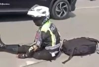 Seorang personel PJR Polda Sumut terduduk di jalan usai terlibat kecelakaan di Medan
