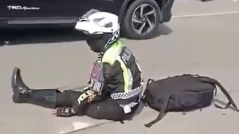 Seorang personel PJR Polda Sumut terduduk di jalan usai terlibat kecelakaan di Medan