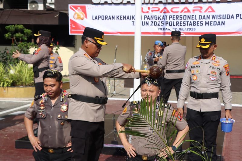 Kapolrestabes Medan, Kombes Pol Gidion Arif Setyawan memandikan personel yang naik pangkat, Rabu (2/7).