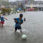 Sejumlah anak-anak bermain sepak bola dalam genangan air di ruas Jalan Sultan Iskandar Muda, Meulaboh, Kabupaten Aceh Barat, saat kawasan tersebut dilanda hujan lebat, Senin (28/4/2025). Foto: Antara