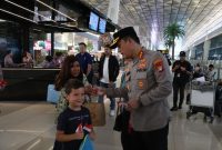 Kapolresta Bandara Soekarno-Hatta Kombes Pol Ronald FC Sipayung membagikan bendera Merah Putih ke sejumlah penumpang di Bandara Internasional Soetta, Tangerang, Banten
