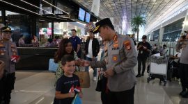 Kapolresta Bandara Soekarno-Hatta Kombes Pol Ronald FC Sipayung membagikan bendera Merah Putih ke sejumlah penumpang di Bandara Internasional Soetta, Tangerang, Banten