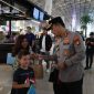 Kapolresta Bandara Soekarno-Hatta Kombes Pol Ronald FC Sipayung membagikan bendera Merah Putih ke sejumlah penumpang di Bandara Internasional Soetta, Tangerang, Banten