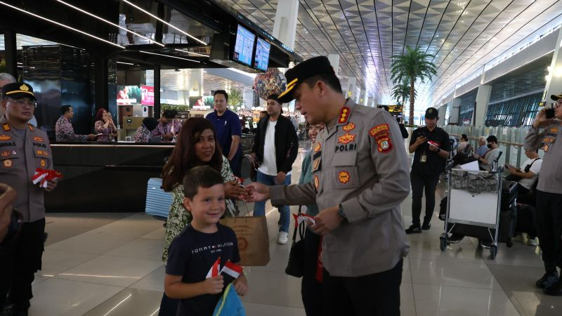 Kapolresta Bandara Soekarno-Hatta Kombes Pol Ronald FC Sipayung membagikan bendera Merah Putih ke sejumlah penumpang di Bandara Internasional Soetta, Tangerang, Banten