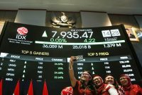 Pekerja Bursa Efek Indonesia (BEI) berswafoto di depan layar digital yang menampilkan pergerakan Indeks Harga Saham Gabungan (IHSG) yang sempat mencapai All Time High (ATH) ke level 8.000 dalam perdagangan intraday saat Presiden Prabowo menyampaikan pidato kenegaraan di Sidang Tahunan MPR, Jakarta, Jumat (15/8/2025)