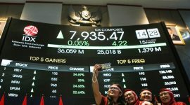 Pekerja Bursa Efek Indonesia (BEI) berswafoto di depan layar digital yang menampilkan pergerakan Indeks Harga Saham Gabungan (IHSG) yang sempat mencapai All Time High (ATH) ke level 8.000 dalam perdagangan intraday saat Presiden Prabowo menyampaikan pidato kenegaraan di Sidang Tahunan MPR, Jakarta, Jumat (15/8/2025)