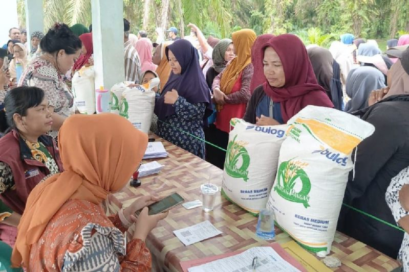 Sejumlah warga menerima bantuan pangan dari pemerintah yang disalurkan Bulog di Kabupaten Simalungun, Sumatera Utara.