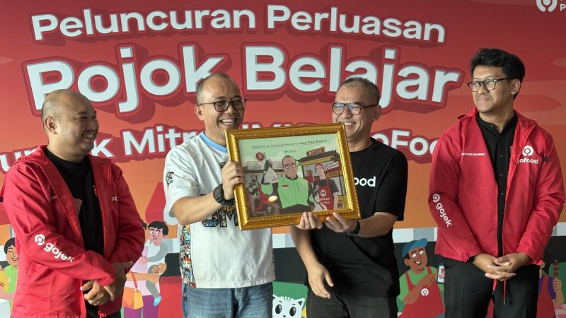 Deputi Bidang Usaha Mikro Kementerian UMKM Riza Adha Damanik (dua dari kiri) menerima cendramata dari pihak GOTO dalam temu media di Jakarta, Jumat (8/8/2025).