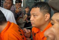 Tersangka kasus dugaan pemerasan terkait pengurusan sertifikat keselamatan dan kesehatan kerja (K3) di lingkungan Kementerian Ketenagakerjaan sekaligus Koordinator Bidang Kelembagaan dan Personel K3 Kemenaker tahun 2022-2025, Irvian Bobby Mahendro (kanan) saat berjalan menuju mobil tahanan di Gedung Merah Putih KPK, Jakarta, Jumat (22/8/2025).