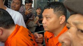 Tersangka kasus dugaan pemerasan terkait pengurusan sertifikat keselamatan dan kesehatan kerja (K3) di lingkungan Kementerian Ketenagakerjaan sekaligus Koordinator Bidang Kelembagaan dan Personel K3 Kemenaker tahun 2022-2025, Irvian Bobby Mahendro (kanan) saat berjalan menuju mobil tahanan di Gedung Merah Putih KPK, Jakarta, Jumat (22/8/2025).