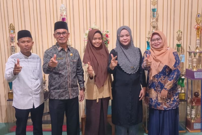 Sisiwa MAN 2 Deli Serdang, Fira Syaqila (tengah) diapit kepala sekolah dan guru-guru. 