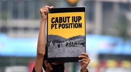 Seorang peserta aksi dengan poster tuntutan pencabutan ijin IUP PT Position. Foto Istimewa